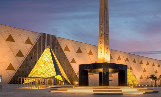 The main triangular glass facade with the pyramids in the background.